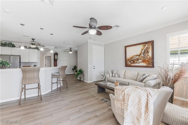 living room featuring light hardwood / wood-style floors, ceiling fan, and ornamental molding