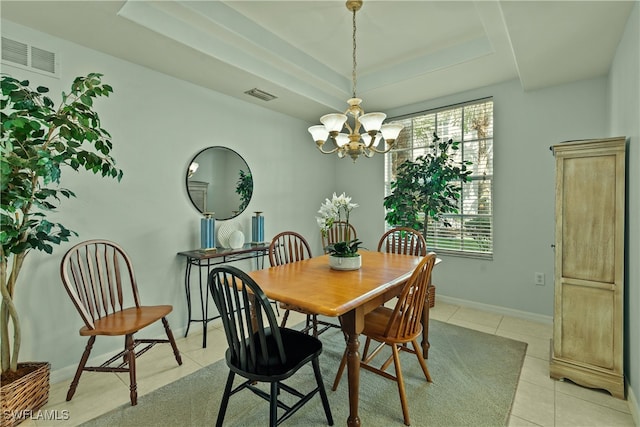 dining space featuring light tile patterned floors, a tray ceiling, and an inviting chandelier