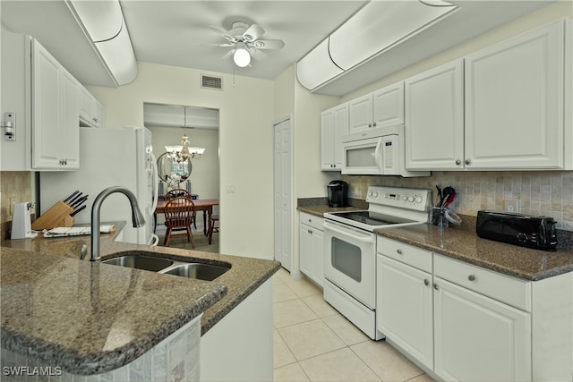 kitchen with white appliances, white cabinetry, dark stone countertops, and sink