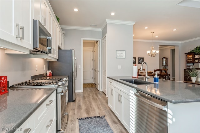 kitchen with white cabinets, sink, light wood-type flooring, stainless steel appliances, and a chandelier