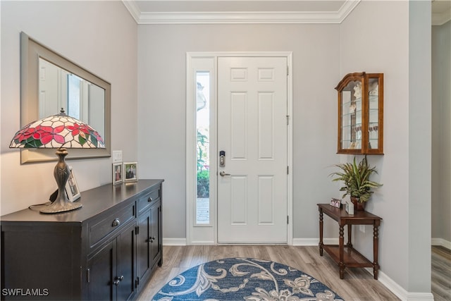 foyer entrance with wood-type flooring, a wealth of natural light, and ornamental molding