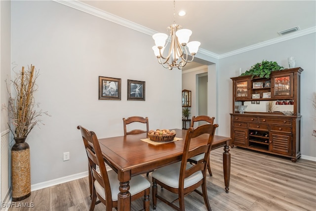 dining room featuring crown molding, a notable chandelier, and hardwood / wood-style flooring