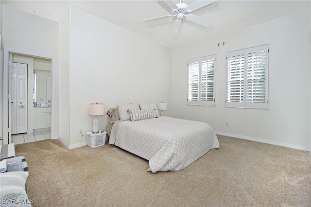 carpeted bedroom with ceiling fan and ensuite bathroom