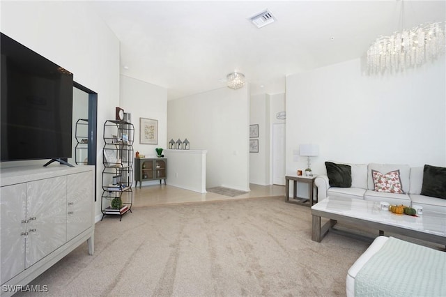 living room featuring light carpet and an inviting chandelier