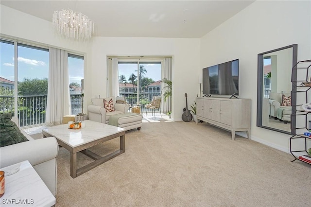 carpeted living room featuring a chandelier