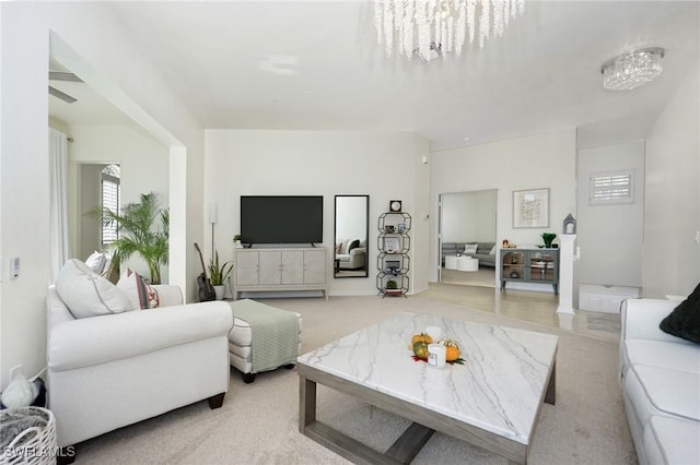 carpeted living room with an inviting chandelier