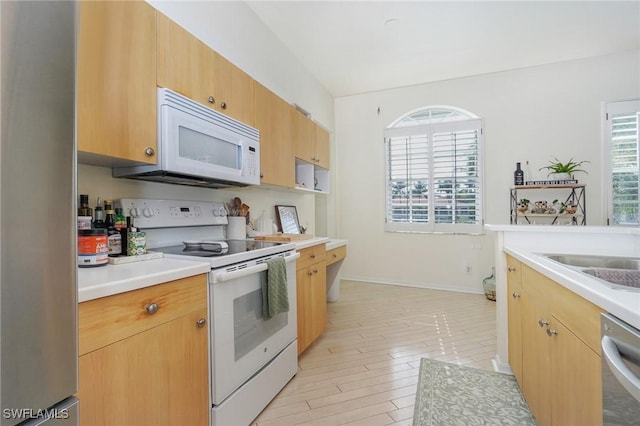 kitchen featuring light wood-type flooring, stainless steel appliances, and sink