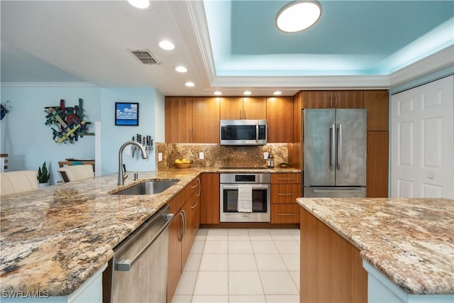 kitchen featuring light stone countertops, sink, and stainless steel appliances