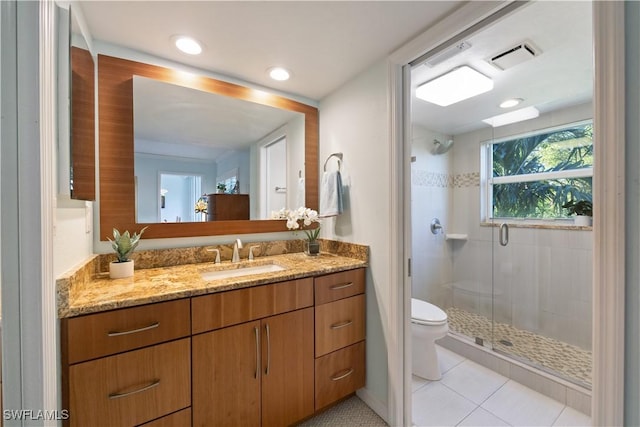 bathroom with vanity, toilet, a shower with shower door, and tile patterned flooring