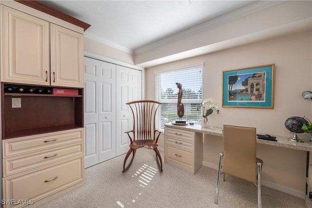 carpeted home office with built in desk and ornamental molding