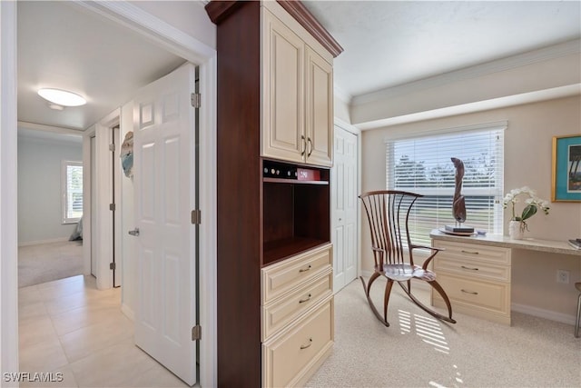 office space with light carpet, crown molding, and built in desk