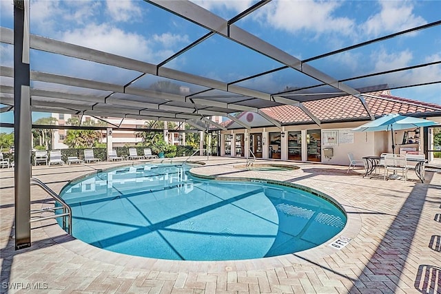 view of swimming pool featuring an in ground hot tub, glass enclosure, and a patio area