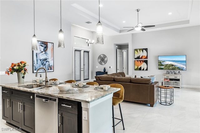 kitchen with a raised ceiling, pendant lighting, sink, and stainless steel dishwasher