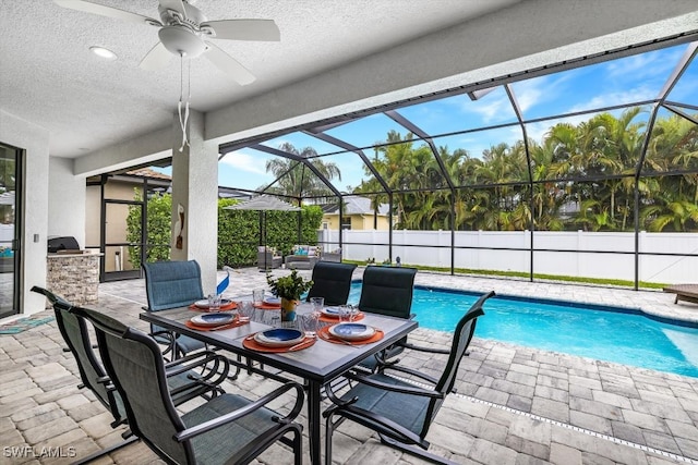 view of pool with a patio, glass enclosure, area for grilling, and ceiling fan