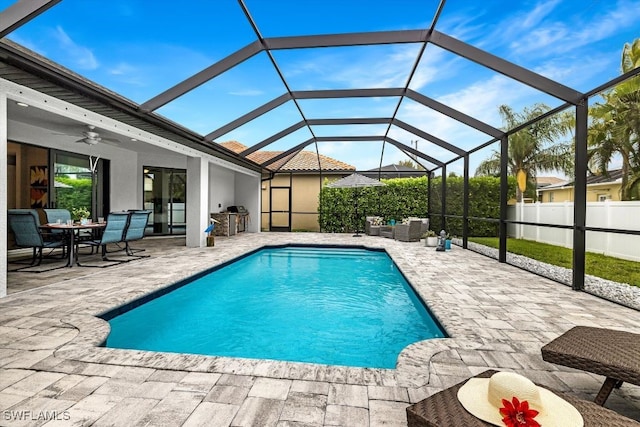 view of pool with outdoor lounge area, a lanai, ceiling fan, and a patio area