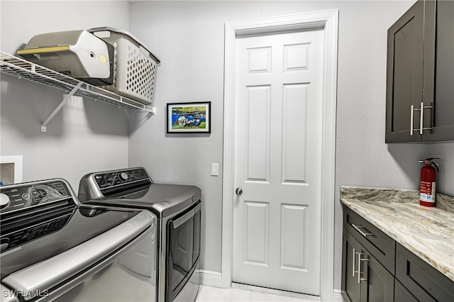 laundry area featuring cabinets, independent washer and dryer, and light tile patterned floors