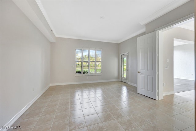 tiled spare room featuring ornamental molding