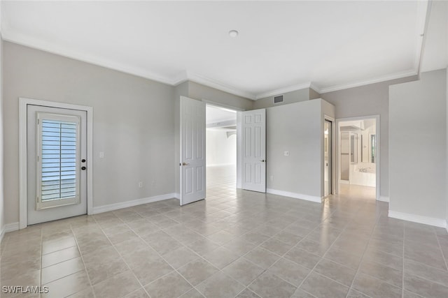 tiled empty room featuring crown molding