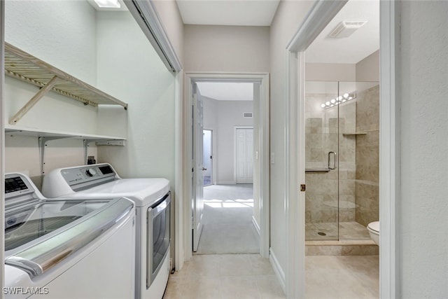 laundry area featuring washer and dryer and light tile patterned floors