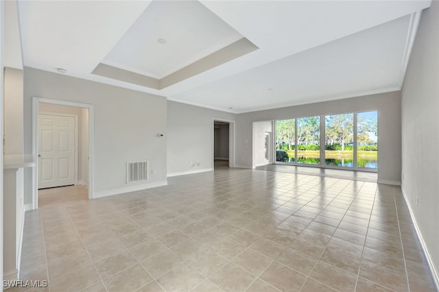 unfurnished room featuring a raised ceiling and light tile patterned floors