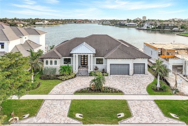 view of front facade with a water view, a front yard, and a garage