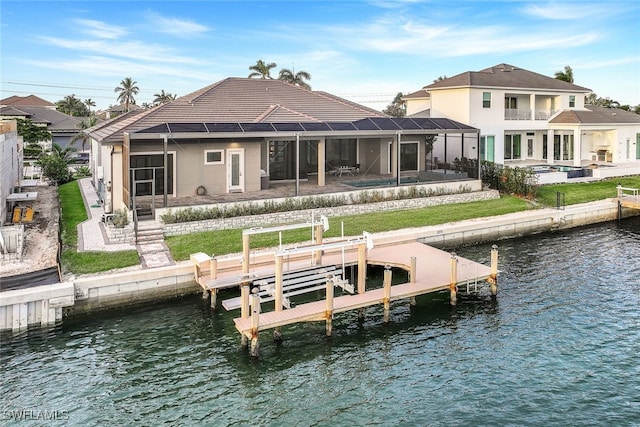 back of house with a lanai, a patio area, a swimming pool, and a water view