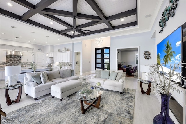 living room with coffered ceiling, french doors, light wood-type flooring, ornamental molding, and beam ceiling