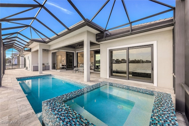 view of swimming pool featuring glass enclosure, ceiling fan, a patio, and an in ground hot tub