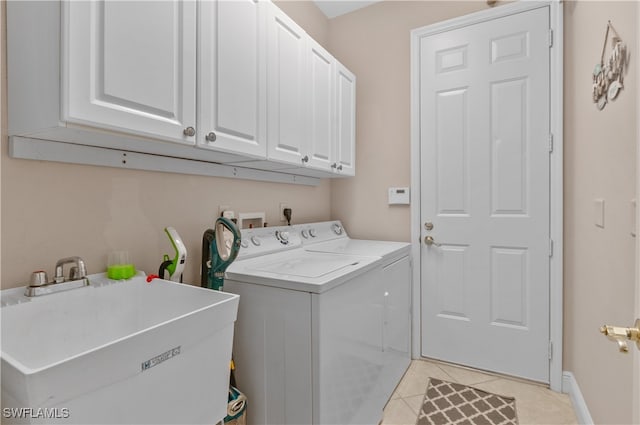 laundry area featuring washer and clothes dryer, cabinets, light tile patterned floors, and sink