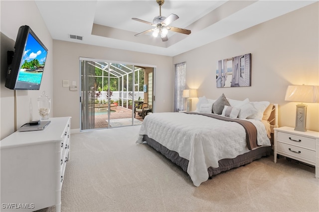 carpeted bedroom with a raised ceiling, access to exterior, and ceiling fan