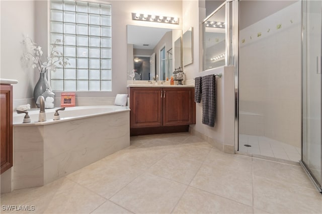 bathroom with tile patterned floors, vanity, and shower with separate bathtub