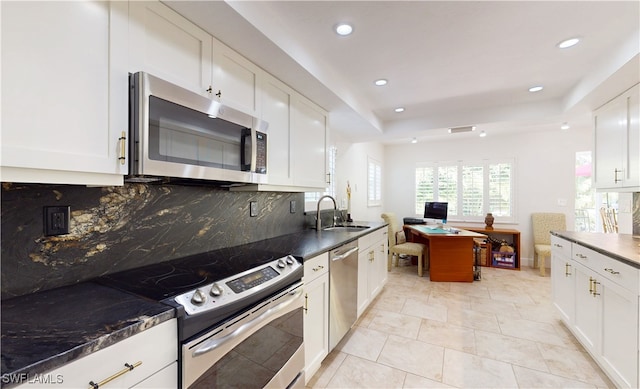 kitchen with decorative backsplash, sink, white cabinets, and appliances with stainless steel finishes