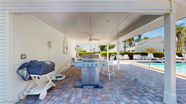 view of patio / terrace with area for grilling, ceiling fan, and a community pool