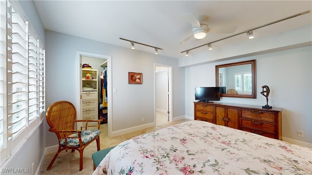 bedroom featuring rail lighting, ceiling fan, a spacious closet, a closet, and light tile patterned flooring