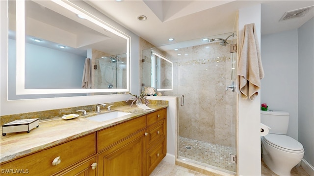 bathroom with a shower with door, vanity, and toilet