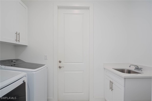 washroom featuring cabinets, independent washer and dryer, and sink