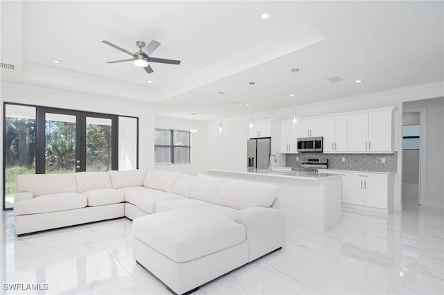 living room with french doors, a raised ceiling, ceiling fan, crown molding, and sink