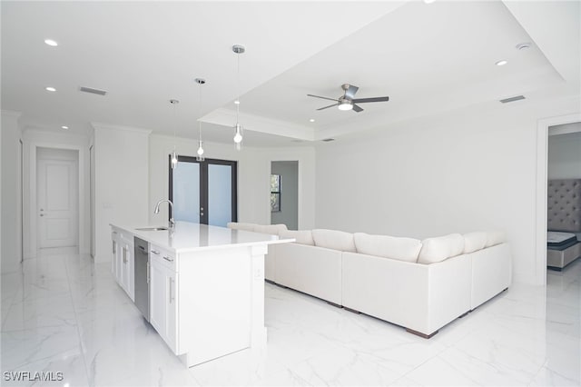 living room with ceiling fan, a raised ceiling, sink, and french doors