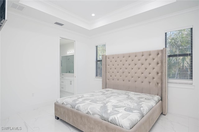 bedroom featuring a tray ceiling, ensuite bath, and crown molding