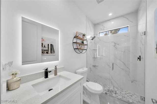 bathroom featuring vanity, toilet, and a shower with shower door