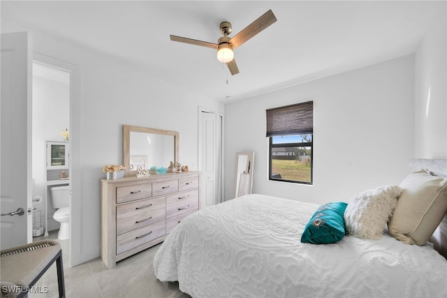 bedroom featuring ceiling fan, light tile patterned flooring, a closet, and ensuite bath