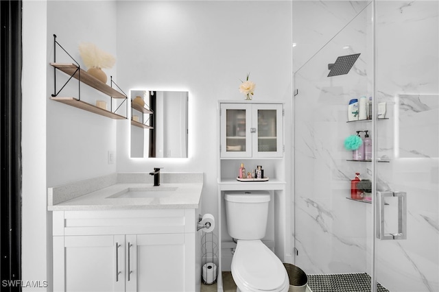 bathroom featuring vanity, toilet, and a shower with shower door