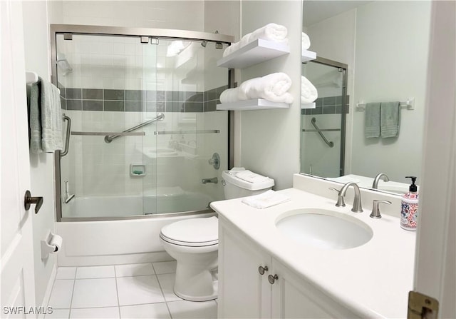 full bathroom with vanity, toilet, shower / bath combination with glass door, and tile patterned floors