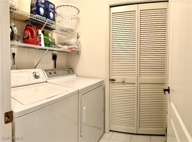 clothes washing area featuring light tile patterned floors and independent washer and dryer