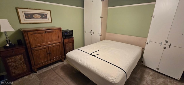 bedroom with dark colored carpet and ornamental molding