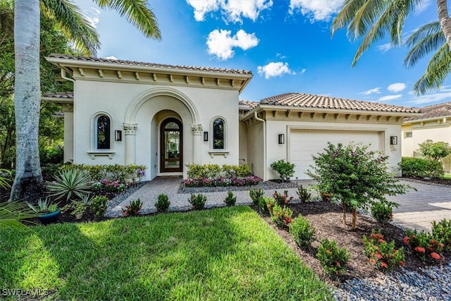 mediterranean / spanish-style house with a front yard and a garage