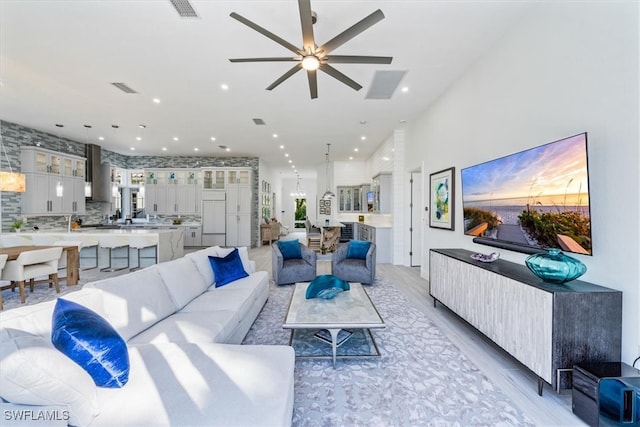 living room with ceiling fan and light hardwood / wood-style flooring