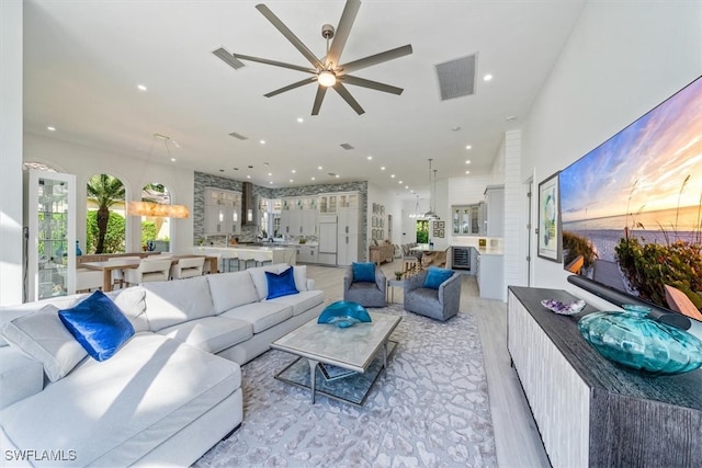 living room with ceiling fan and light wood-type flooring