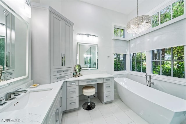 bathroom featuring vanity, a tub to relax in, an inviting chandelier, and a wealth of natural light