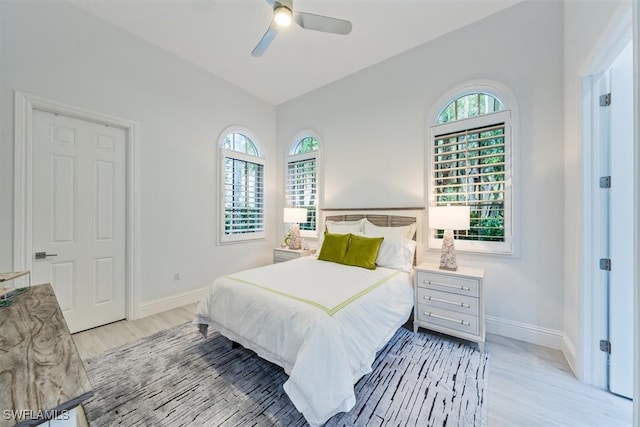 bedroom with multiple windows, ceiling fan, and light hardwood / wood-style floors